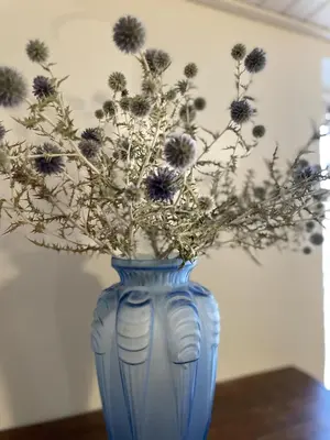 a blue vase with flowers in it on a table at Le Taurillou in Taurize