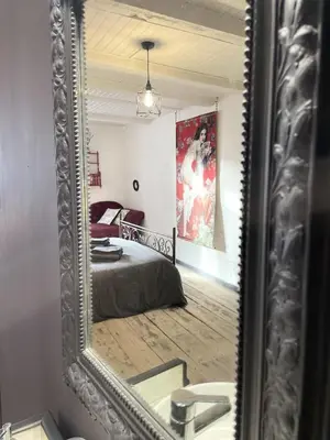 a mirror reflection of a bedroom with a bed at Le Taurillou in Taurize
