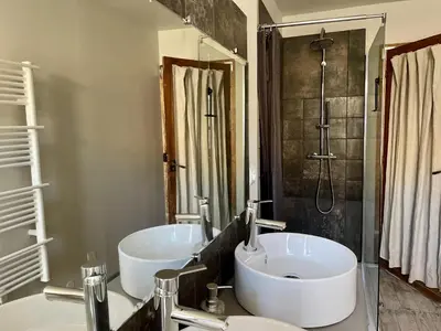 a bathroom with two sinks and a tub and a shower at Le Taurillou in Taurize