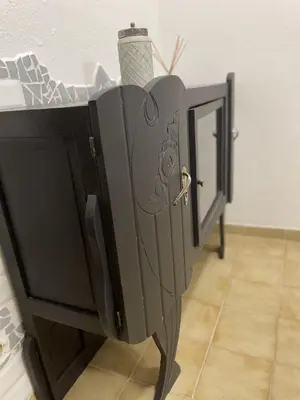 a black cabinet with a mirror in a room at Le Taurillou in Taurize