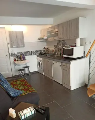 a small kitchen with a couch and a microwave at Escale à Castelnaudary in Castelnaudary