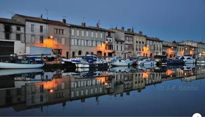 a group of boats docked in a marina at night at Escale à Castelnaudary in Castelnaudary