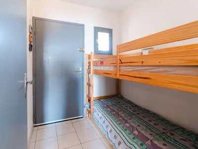 a room with two bunk beds and a door at Studio cabine avec piscine et vue port à Gruissan - FR-1-409-199 in Gruissan