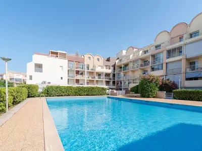 a swimming pool in front of a apartment building at Studio cabine avec piscine et vue port à Gruissan - FR-1-409-199 in Gruissan