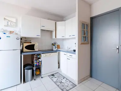 a kitchen with white cabinets and a white refrigerator at Studio cabine avec piscine et vue port à Gruissan - FR-1-409-199 in Gruissan