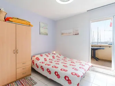 a bedroom with a bed and a dresser and a window at Studio cabine avec piscine et vue port à Gruissan - FR-1-409-199 in Gruissan