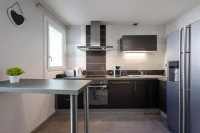 a kitchen with a counter and a refrigerator at L'Évêché - T3 Spacieux & Traversant en Hypercentre in Castres