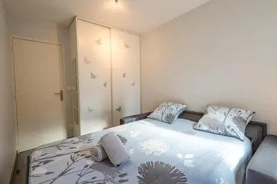 a bedroom with a bed with a blue comforter at L'Évêché - T3 Spacieux & Traversant en Hypercentre in Castres