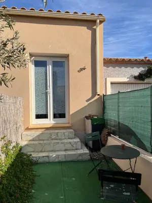 a house with a patio with a table and a window at Le CLOS du LÉZARD - L'escapade in Port-la-Nouvelle