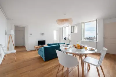 a living room with a blue couch and a table at Charmand duplex avec vue sur la cité & les toits in Carcassonne