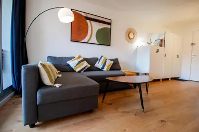 a living room with a couch and a table at Logis des Goélands YourHostHelper in Gruissan