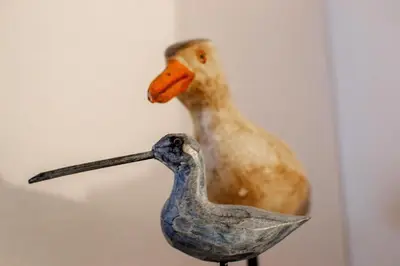a statue of a duck sitting on top of a bird statue at Logis des Goélands YourHostHelper in Gruissan