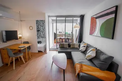 a living room with a couch and a table at Logis des Goélands YourHostHelper in Gruissan