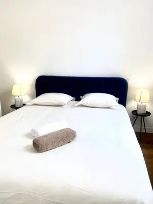 a large white bed with two pillows and two lamps at *Chic & Basic T3* place Carnot in Carcassonne