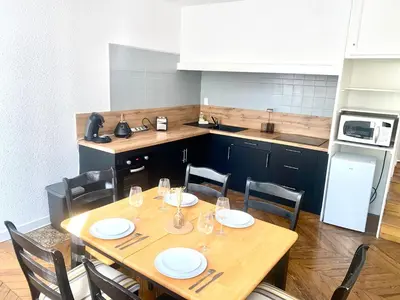 a kitchen with a wooden table and chairs with glasses on it at *Chic & Basic T3* place Carnot in Carcassonne