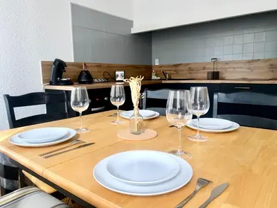 a wooden table with plates and wine glasses on it at *Chic & Basic T3* place Carnot in Carcassonne