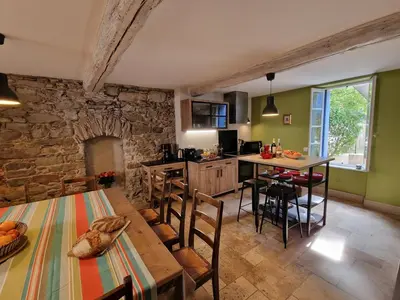 a kitchen and dining room with a table and chairs at L'Orée de la cité in Carcassonne