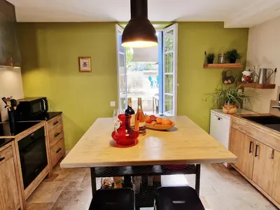 a kitchen with a table with a bowl of fruit on it at L'Orée de la cité in Carcassonne