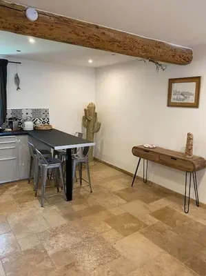 a kitchen with a table and a bench in a room at Maison Marceau Gruissan in Gruissan