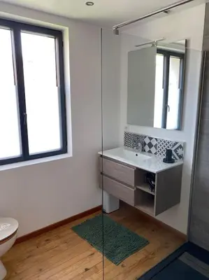 a bathroom with a sink and a glass shower at Maison Marceau Gruissan in Gruissan