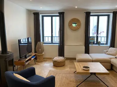 a living room with a couch and a tv at Maison Marceau Gruissan in Gruissan