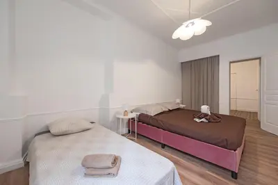 a bedroom with two beds and a table and a lamp at Le Louis XVI - Majestueux Appart Centre Ville in Carcassonne