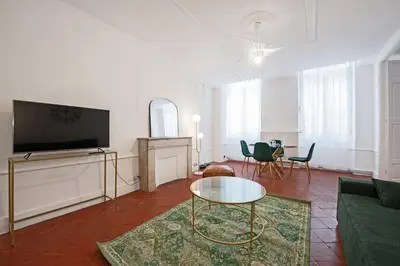 a living room with a tv and a couch and a table at Le Louis XVI - Majestueux Appart Centre Ville in Carcassonne