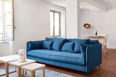 a blue couch in a living room with a table at Les Colonnes - T3 - Bastide in Carcassonne