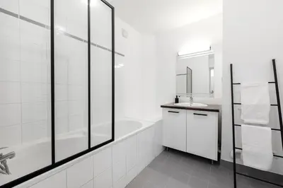 a white bathroom with a tub and a sink at Les Colonnes - T3 - Bastide in Carcassonne