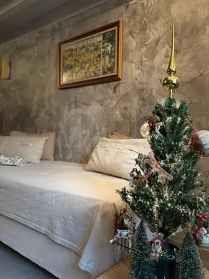 a bedroom with a christmas tree in front of a bed at la maison des lauriers rouges in Peyriac-de-Mer