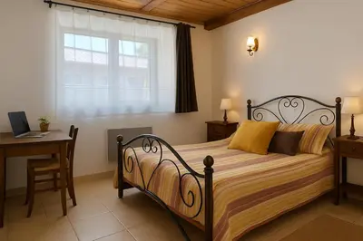 a bedroom with a bed with a desk and a window at Gite été in Le Soulié