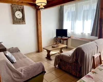 a room with two beds and a table with a tv at Gite été in Le Soulié