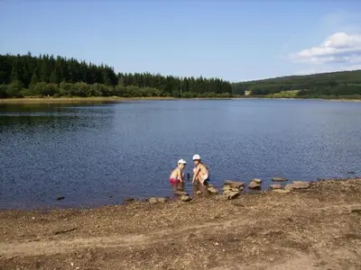 two people standing on the shore of a lake at Gite été in Le Soulié