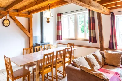 a dining room with a table and a couch at Gite été in Le Soulié