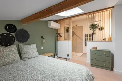 a bedroom with a bed and a refrigerator in it at Le Blackwood in Mazamet