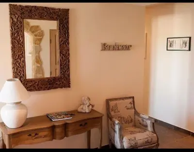 a room with a table and a chair and a mirror at Villa les Deux Cypres in Saint-Laurent-de-la-Cabrerisse