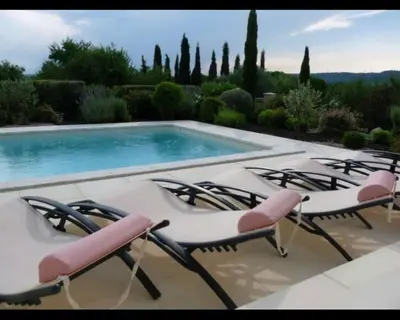 a group of chairs sitting next to a swimming pool at Villa les Deux Cypres in Saint-Laurent-de-la-Cabrerisse