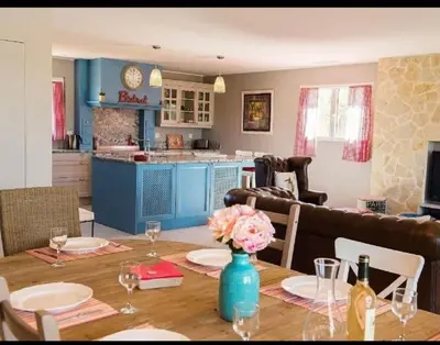 a dining room and kitchen with a table with flowers on it at Villa les Deux Cypres in Saint-Laurent-de-la-Cabrerisse
