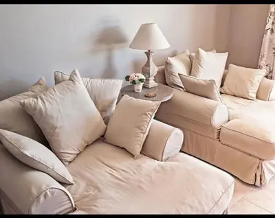 a living room with a white couch with pillows at Villa les Deux Cypres in Saint-Laurent-de-la-Cabrerisse