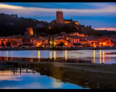a town at night with a body of water at Villa les Deux Cypres in Saint-Laurent-de-la-Cabrerisse