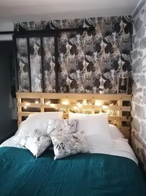 a bedroom with a bed with white sheets and pillows at Charmant appartement de village in Pennautier