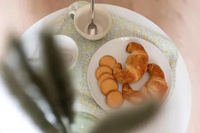 a plate of food with croissants on a table at Le Cottage in Mazamet