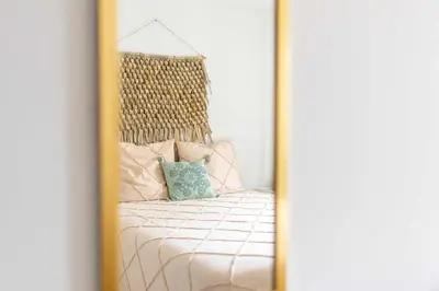 a mirror reflection of a bed in a bedroom at Le Cottage in Mazamet