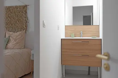 a bedroom with a sink and a bed with a mirror at Le Cottage in Mazamet