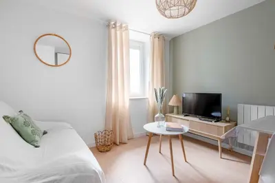 a bedroom with a bed and a tv and a table at Le Cottage in Mazamet