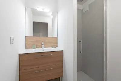 a bathroom with a sink and a mirror and a shower at Le Cottage in Mazamet