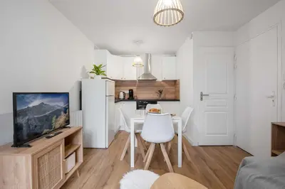 a kitchen and living room with a table and a refrigerator at Le Polaire in Mazamet