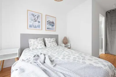 a white bedroom with a bed with a white blanket at Le Polaire in Mazamet