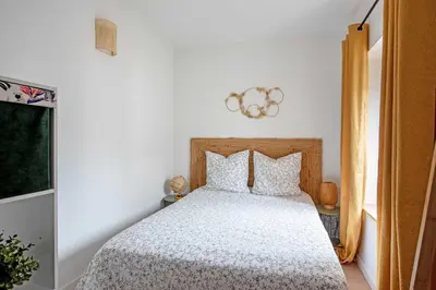 a bedroom with a bed with a white comforter at Le Tropical : T2 rénové Ambiance Cosy et Colorée in Mazamet