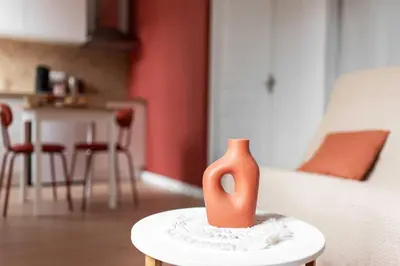 a orange vase sitting on a table in a room at Agréable studio cosy entièrement rénové in Mazamet